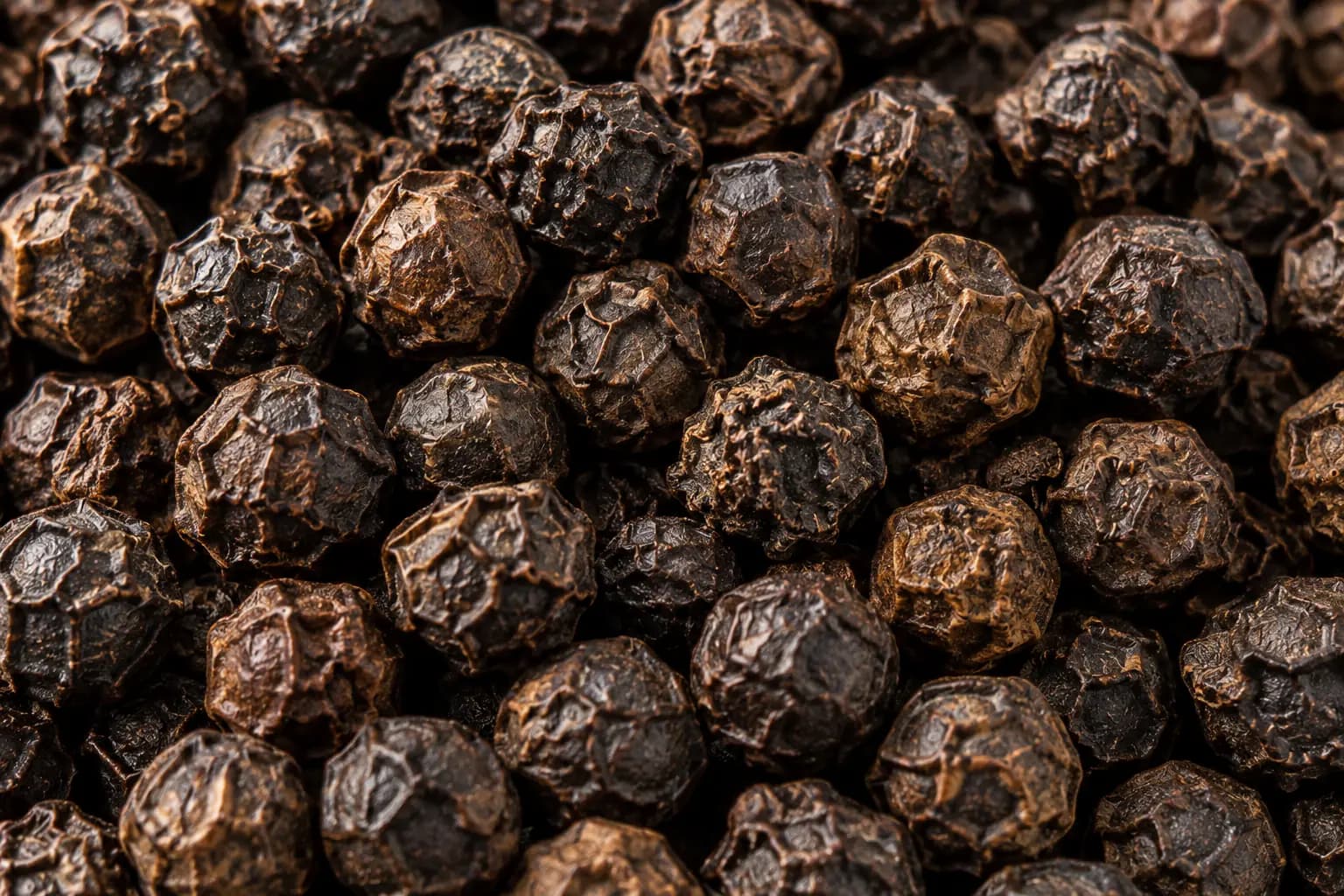 Close-up of whole black peppercorns